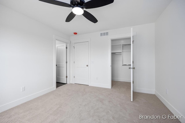 unfurnished bedroom with visible vents, a walk in closet, ceiling fan, baseboards, and carpet floors