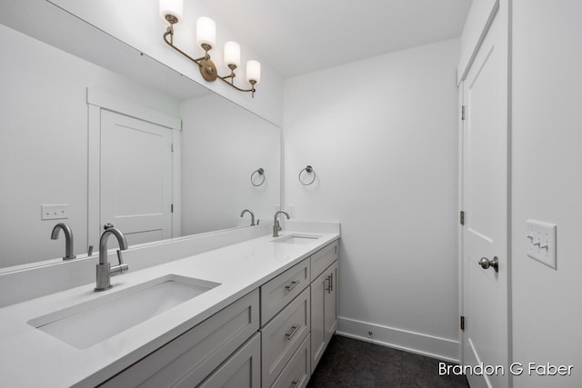 full bath with a sink, baseboards, and double vanity