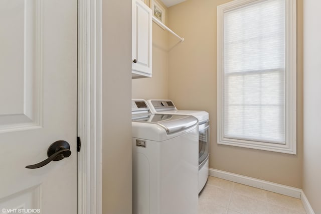 clothes washing area featuring washer and dryer, plenty of natural light, cabinet space, and light tile patterned flooring