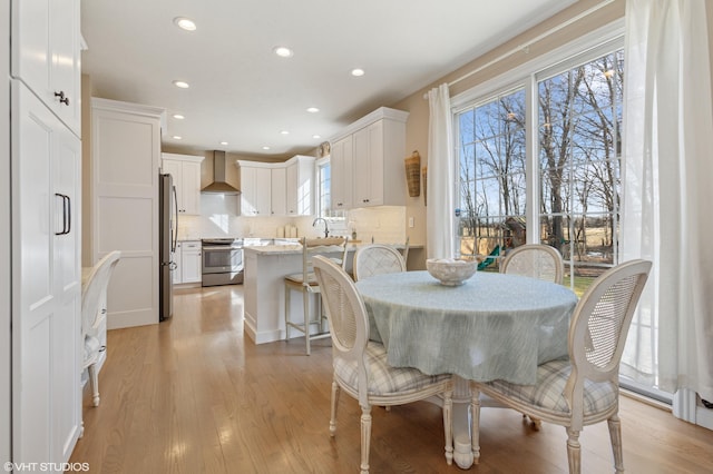 dining space featuring recessed lighting and light wood-style flooring