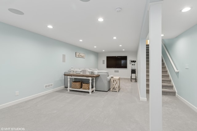 carpeted living area with recessed lighting, visible vents, baseboards, and stairs