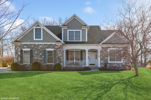 view of front facade with stone siding, a porch, a front lawn, and roof with shingles