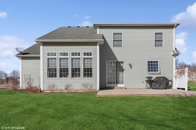 back of property featuring a lawn, a patio, and roof with shingles