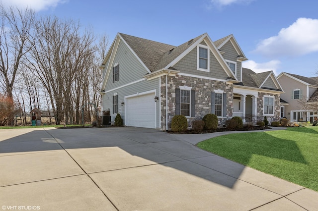 view of front of home featuring stone siding, a shingled roof, concrete driveway, an attached garage, and a front yard