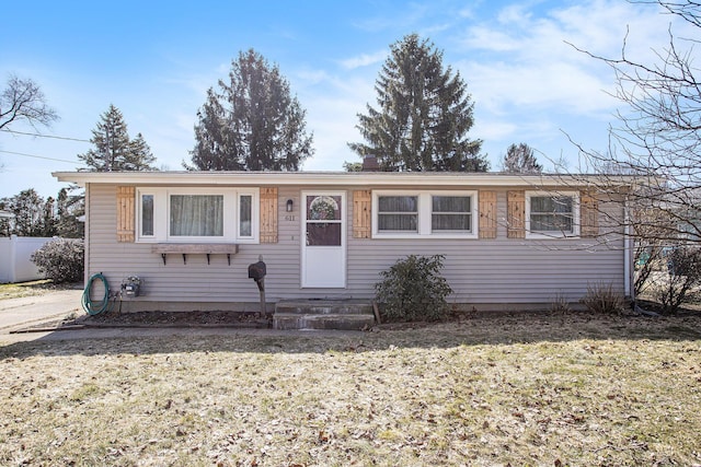 view of front facade with a front lawn and fence