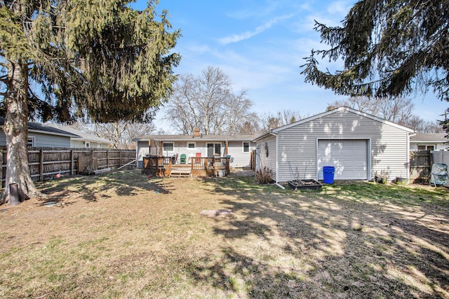 back of house with a garage, a wooden deck, a fenced backyard, and an outdoor structure