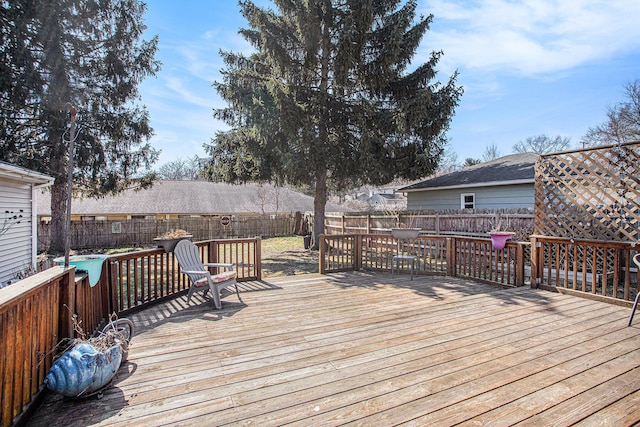 wooden terrace with a fenced backyard