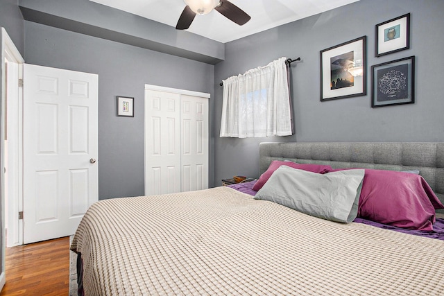 bedroom featuring ceiling fan, a closet, and wood finished floors