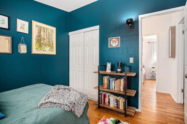 bedroom featuring wood finished floors, a closet, and baseboards