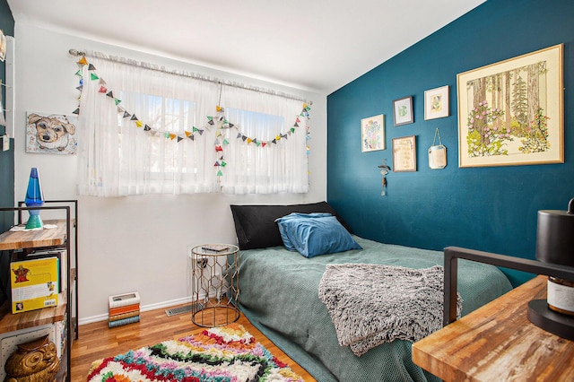 bedroom featuring baseboards and wood finished floors