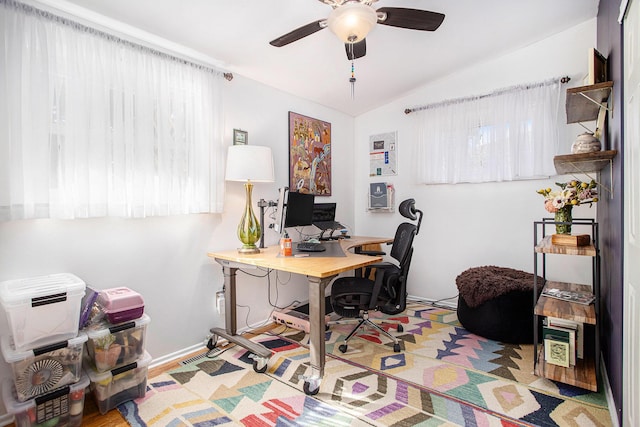 office space featuring lofted ceiling, a ceiling fan, and baseboards