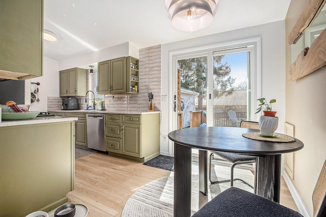 kitchen with light wood-style floors, stainless steel dishwasher, gray cabinetry, and light countertops