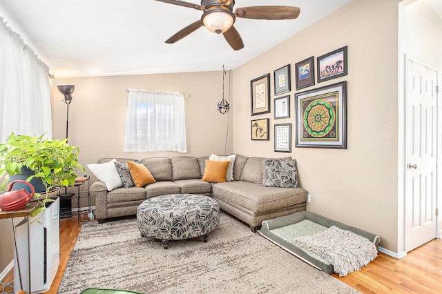 living area with wood finished floors, baseboards, and ceiling fan