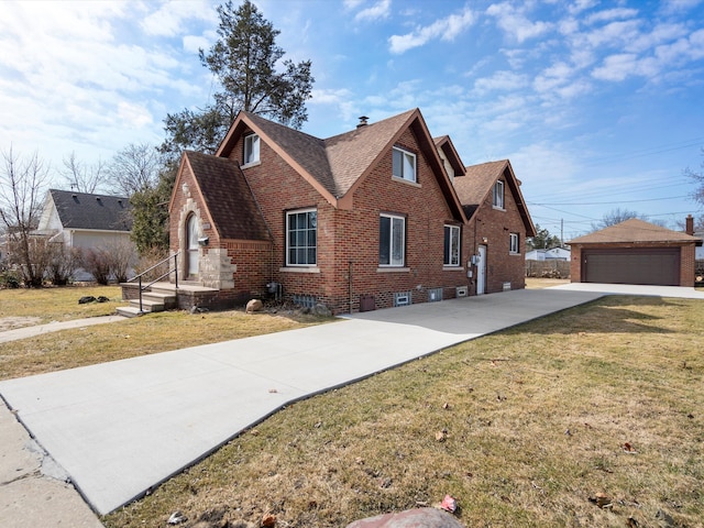 view of front of house featuring brick siding, a front lawn, an outbuilding, and roof with shingles