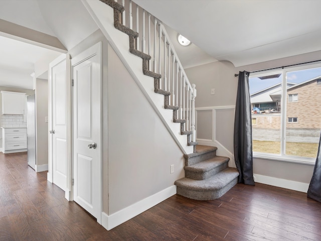 staircase with a wealth of natural light, baseboards, and wood finished floors