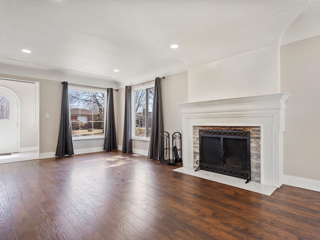 unfurnished living room with a premium fireplace, recessed lighting, baseboards, and wood finished floors