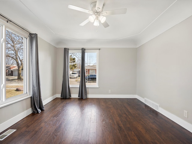 unfurnished room with visible vents, baseboards, hardwood / wood-style floors, and a ceiling fan