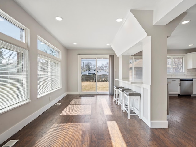 unfurnished dining area with visible vents, recessed lighting, dark wood-style floors, and baseboards