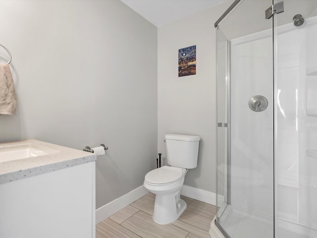 bathroom featuring baseboards, toilet, a stall shower, and vanity