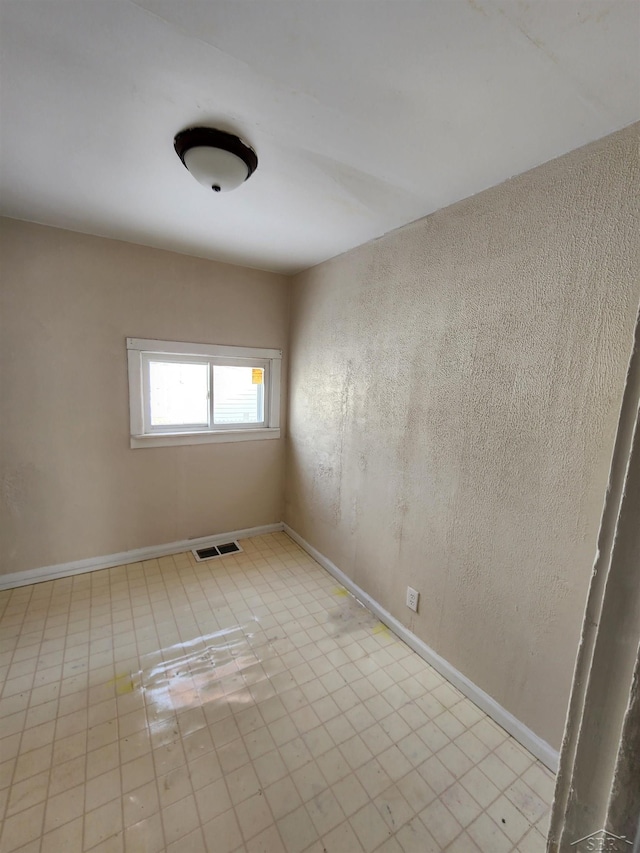 spare room with baseboards and visible vents