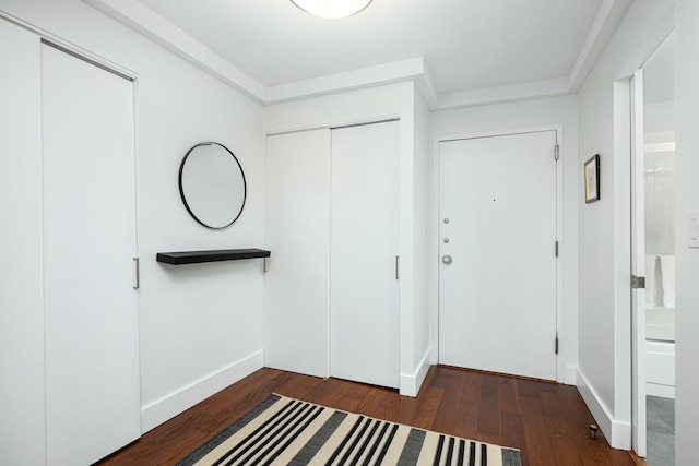 foyer featuring baseboards and wood finished floors