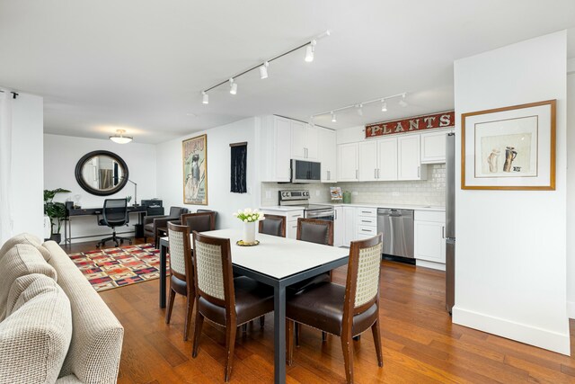 dining space with baseboards and dark wood-type flooring