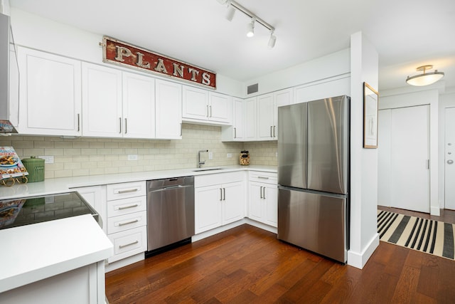 kitchen with a sink, appliances with stainless steel finishes, dark wood-style floors, and light countertops