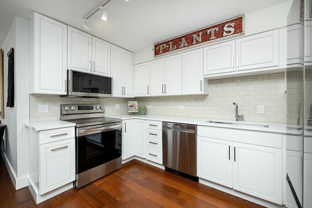 kitchen with dark wood-style flooring, stainless steel appliances, light countertops, and a sink