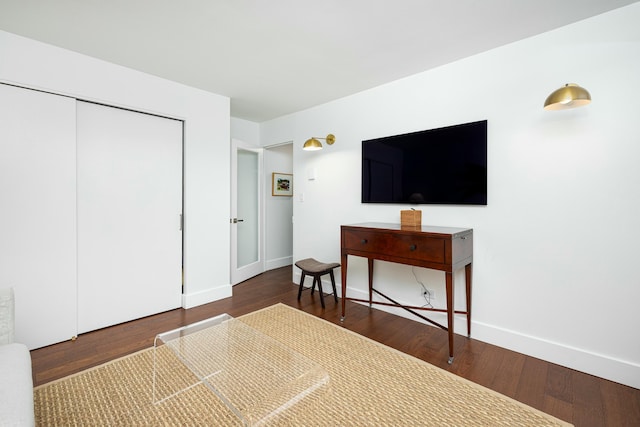 bedroom featuring wood finished floors, baseboards, and a closet