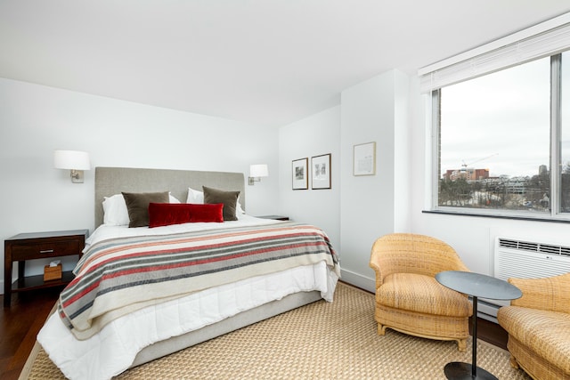 bedroom featuring wood finished floors and a wall mounted AC