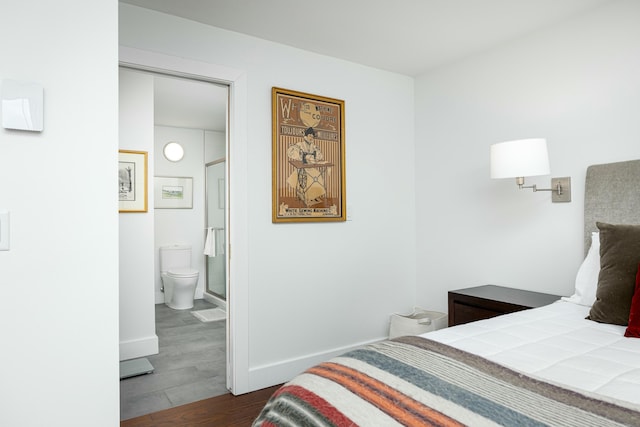 bedroom featuring ensuite bathroom, baseboards, and dark wood-style flooring