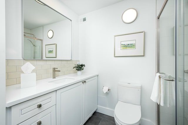 bathroom with tasteful backsplash, tiled shower, toilet, and vanity