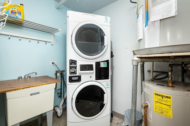 washroom with water heater, tile patterned flooring, laundry area, and stacked washer and dryer