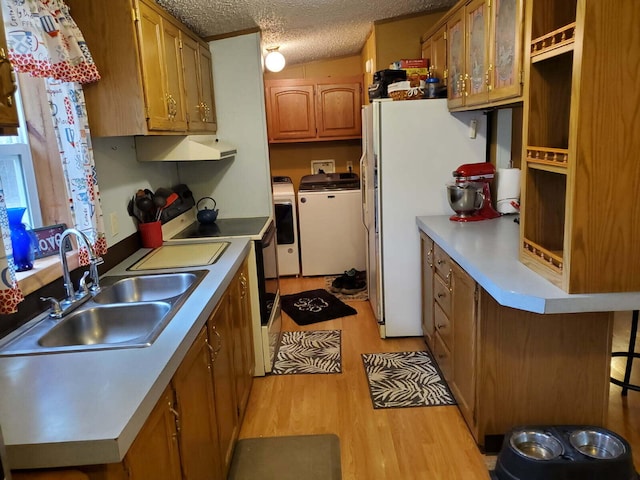 kitchen with independent washer and dryer, electric stove, a sink, under cabinet range hood, and a textured ceiling