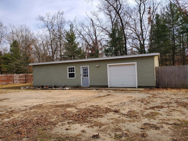 detached garage featuring fence