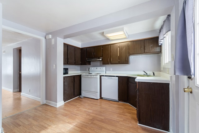 kitchen featuring a sink, light wood-type flooring, white appliances, and light countertops