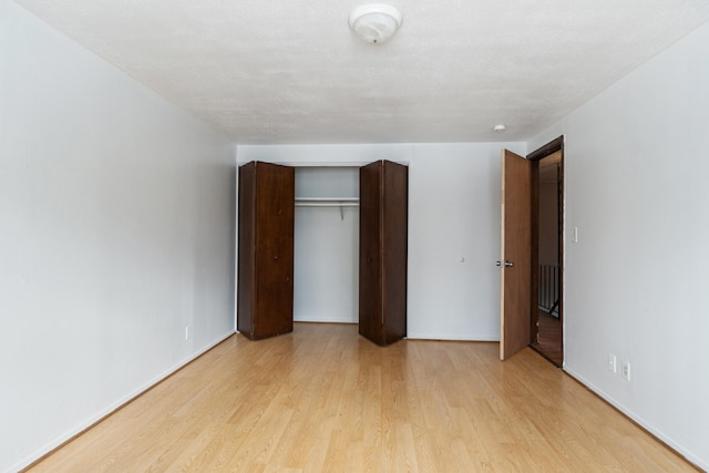 unfurnished bedroom featuring a closet and light wood-style flooring