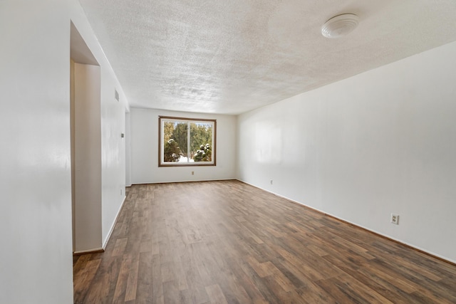 empty room featuring a textured ceiling and wood finished floors