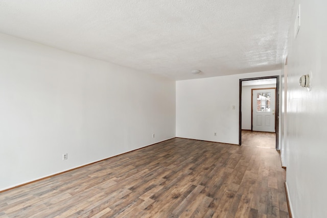 empty room featuring a textured ceiling and wood finished floors