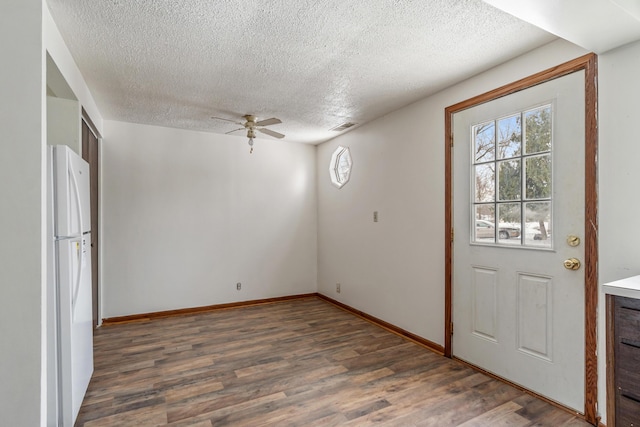 interior space with wood finished floors, a ceiling fan, visible vents, and a textured ceiling