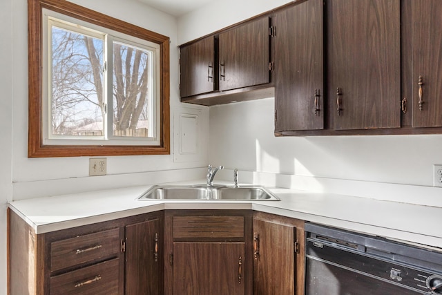 kitchen featuring dark brown cabinets, dishwasher, light countertops, and a sink