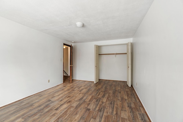 unfurnished bedroom featuring a closet, a textured ceiling, and wood finished floors