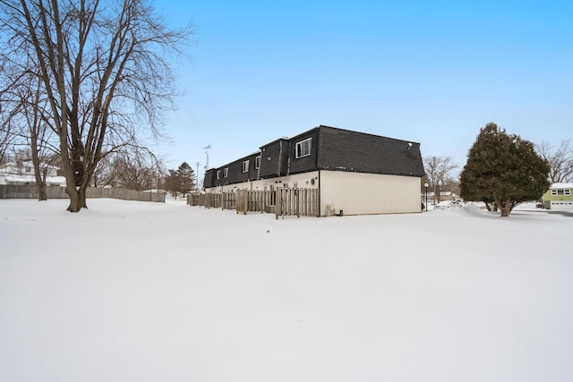 snow covered property featuring fence