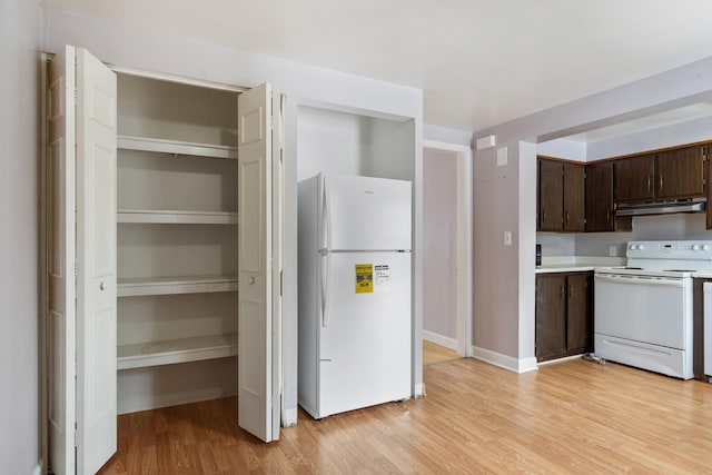 kitchen featuring under cabinet range hood, white appliances, light wood-style floors, light countertops, and dark brown cabinets