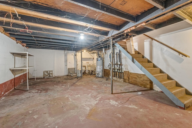 unfinished basement featuring stairway and water heater