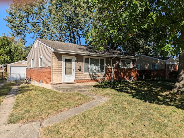 view of front of house featuring driveway, a detached garage, an outdoor structure, a front yard, and brick siding