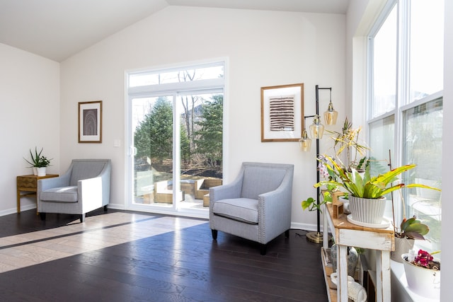 living area with vaulted ceiling, baseboards, and hardwood / wood-style flooring