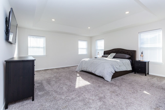 carpeted bedroom with recessed lighting, a raised ceiling, and baseboards