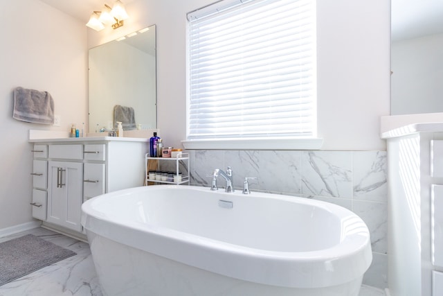 full bathroom featuring a soaking tub, marble finish floor, and vanity