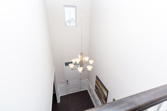 staircase with an inviting chandelier and wood finished floors